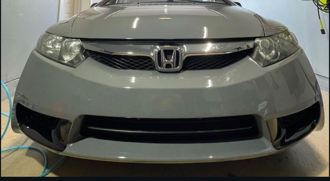 Honda Civic front end in gray primer in the paint bay