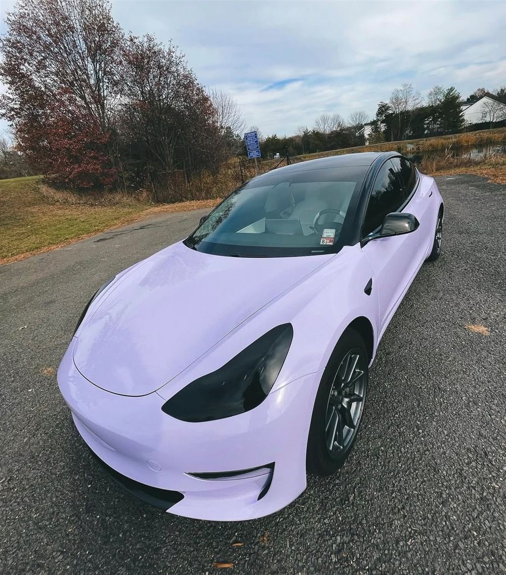 Lilac Tesla Model 3 with blacked-out headlights