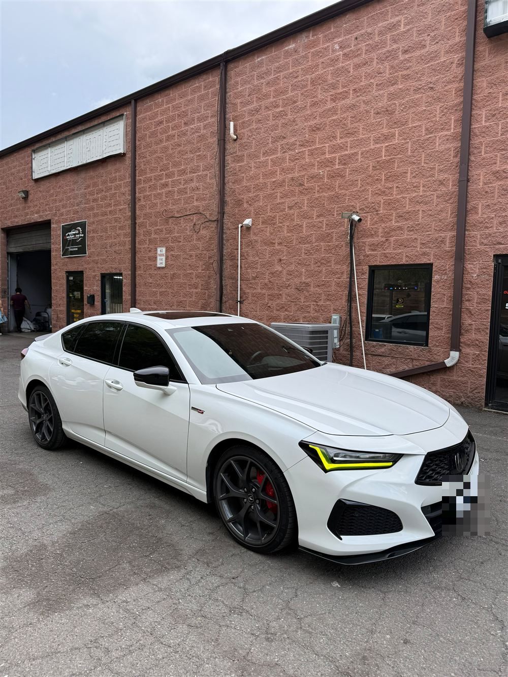 White Acura TLX with yellow daytime running lights