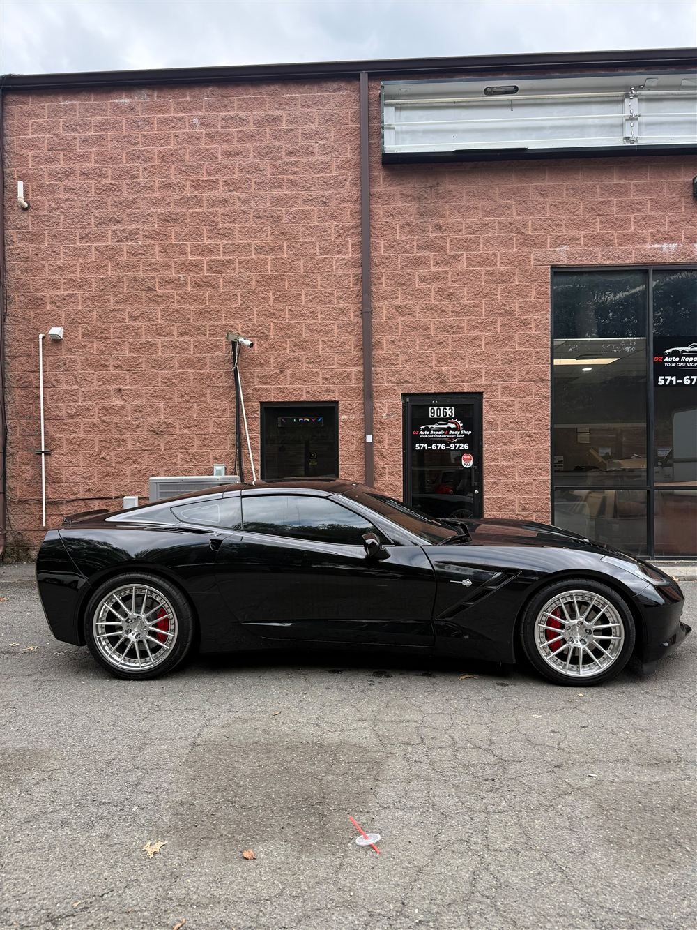 Black C7 Corvette with silver wheels outside the shop