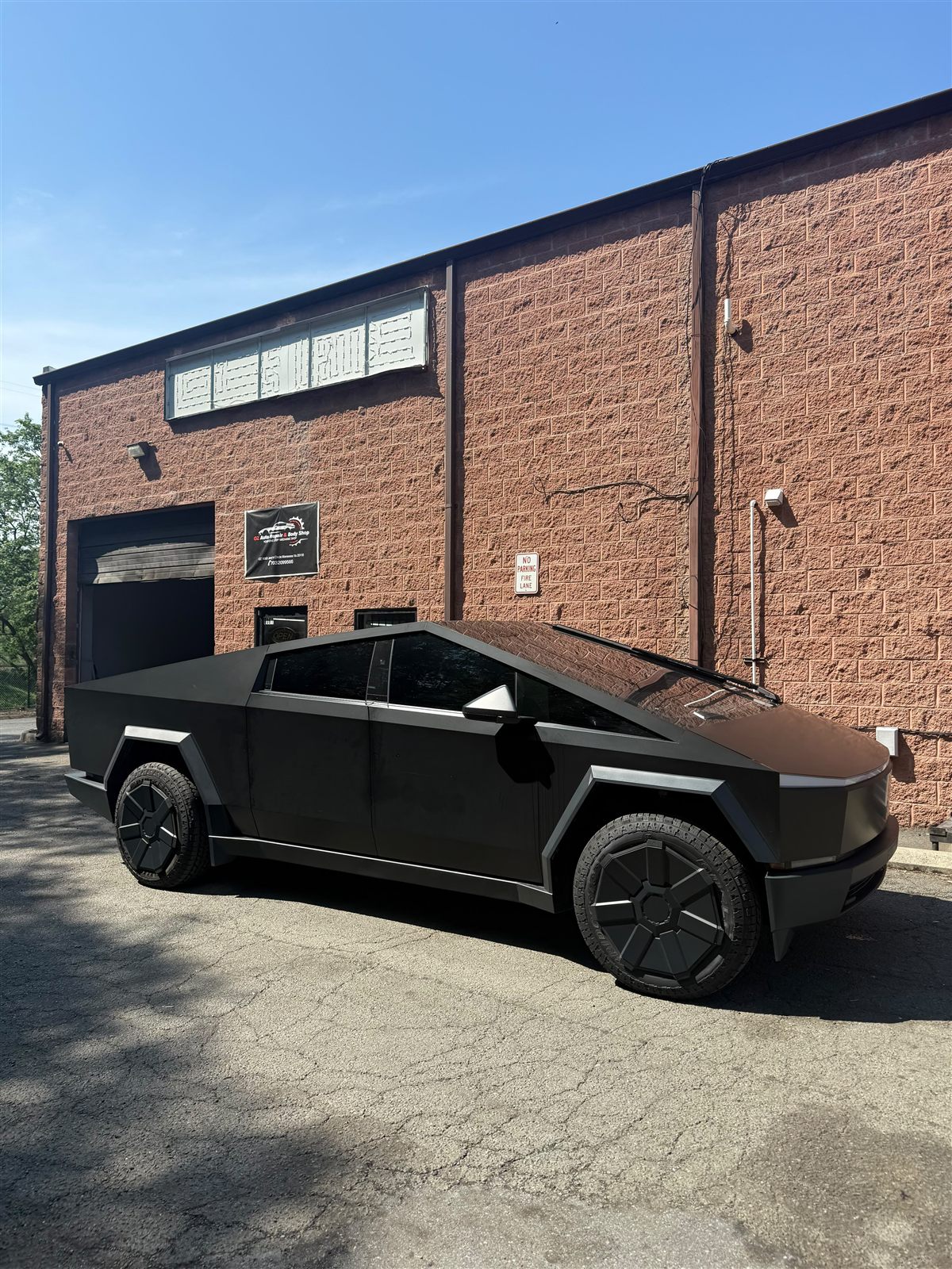 Blacked-out Tesla Cybertruck with dark tinted windows outside the OZ shop