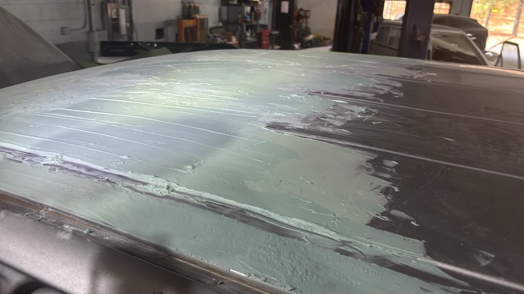 Body filler shaped across a damaged panel