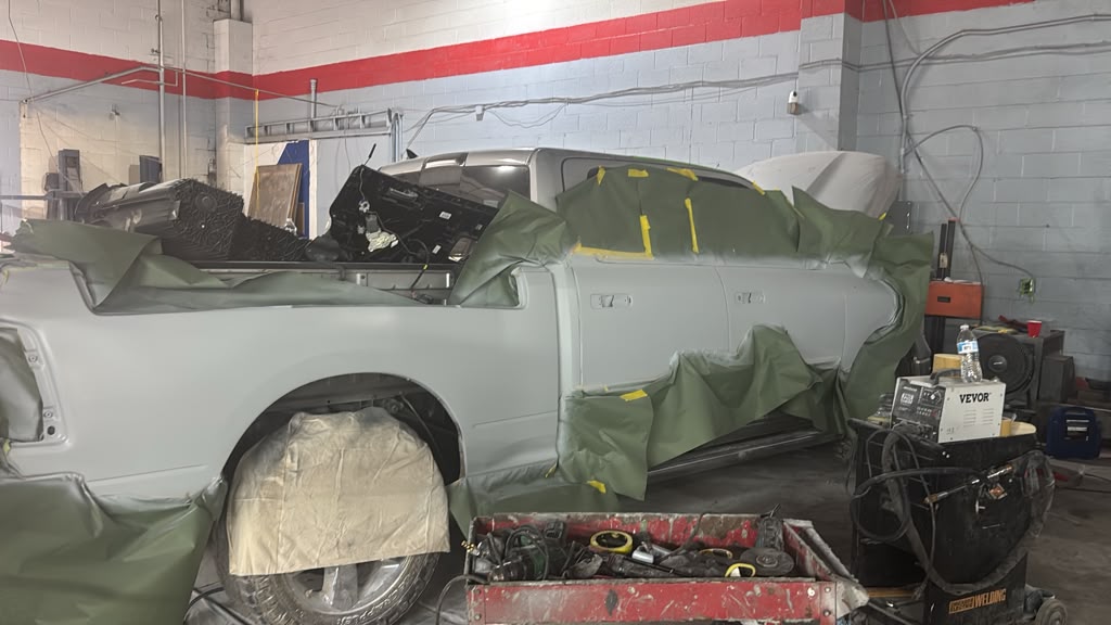 Technician sanding the side of the truck in the bay